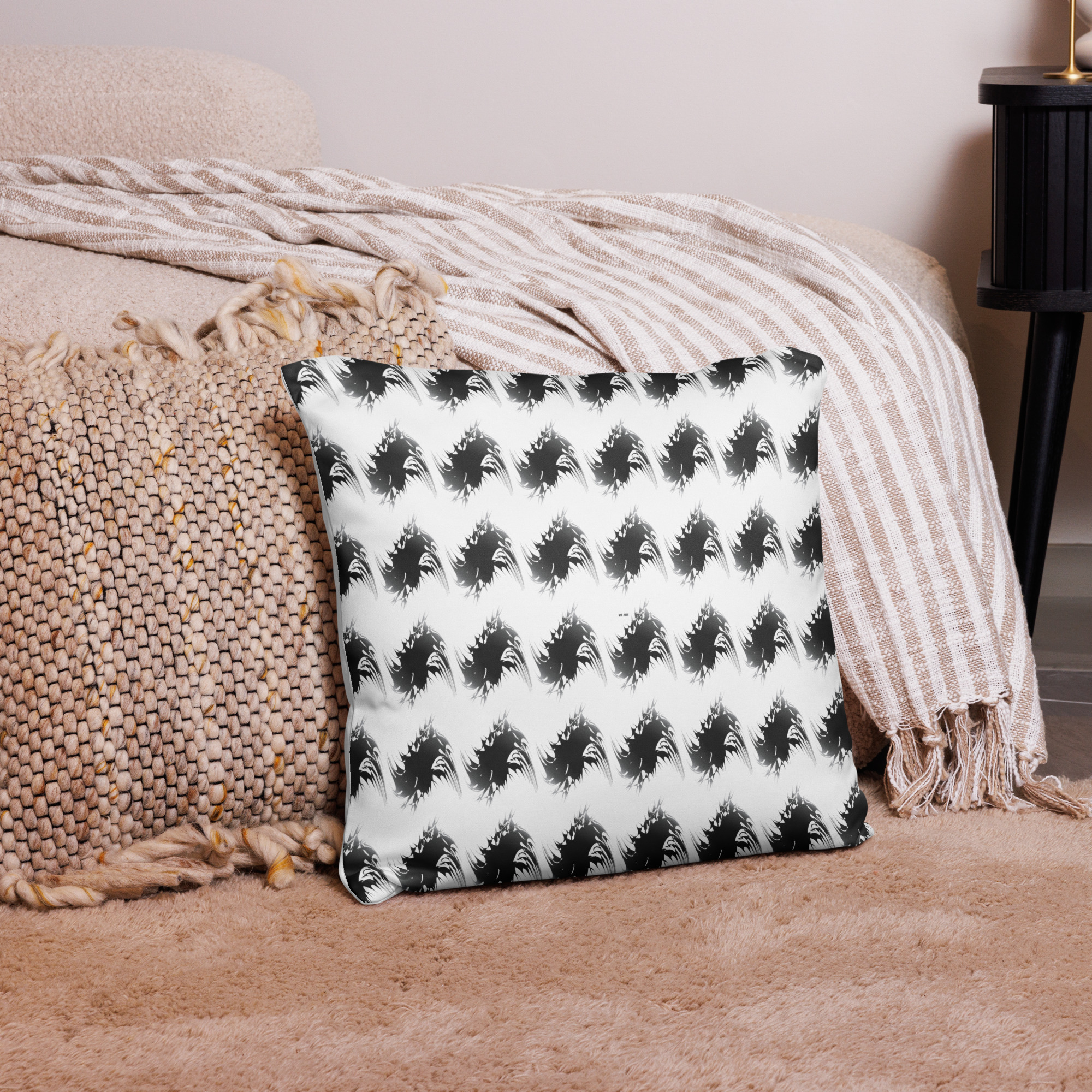 Square white cushion with repeating black geometric leaf-like shapes arranged in uniform rows creating a modern abstract pattern