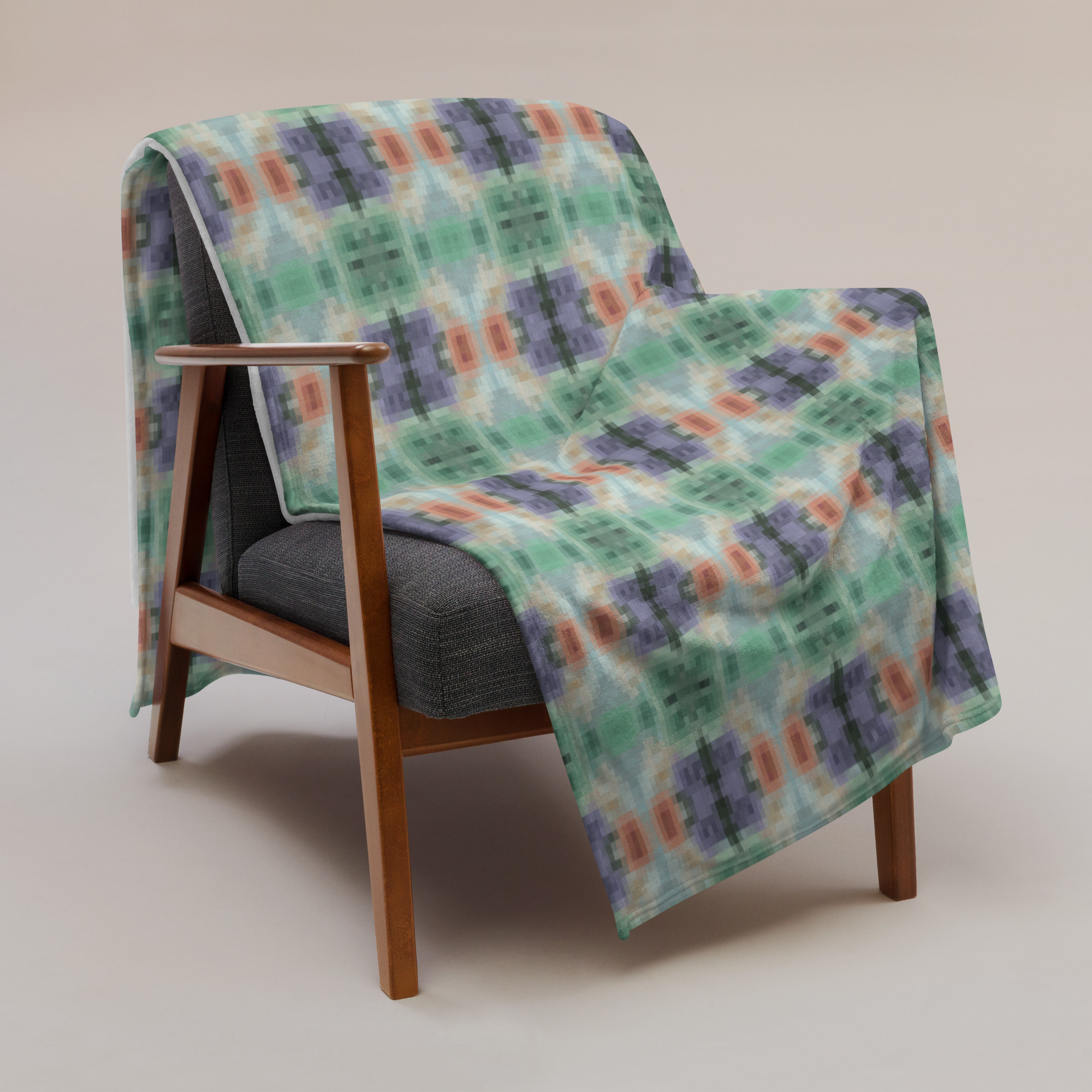Colorful geometric pattern blanket showing diamond and oval motifs in repeating design with mint green, coral and cream colors
